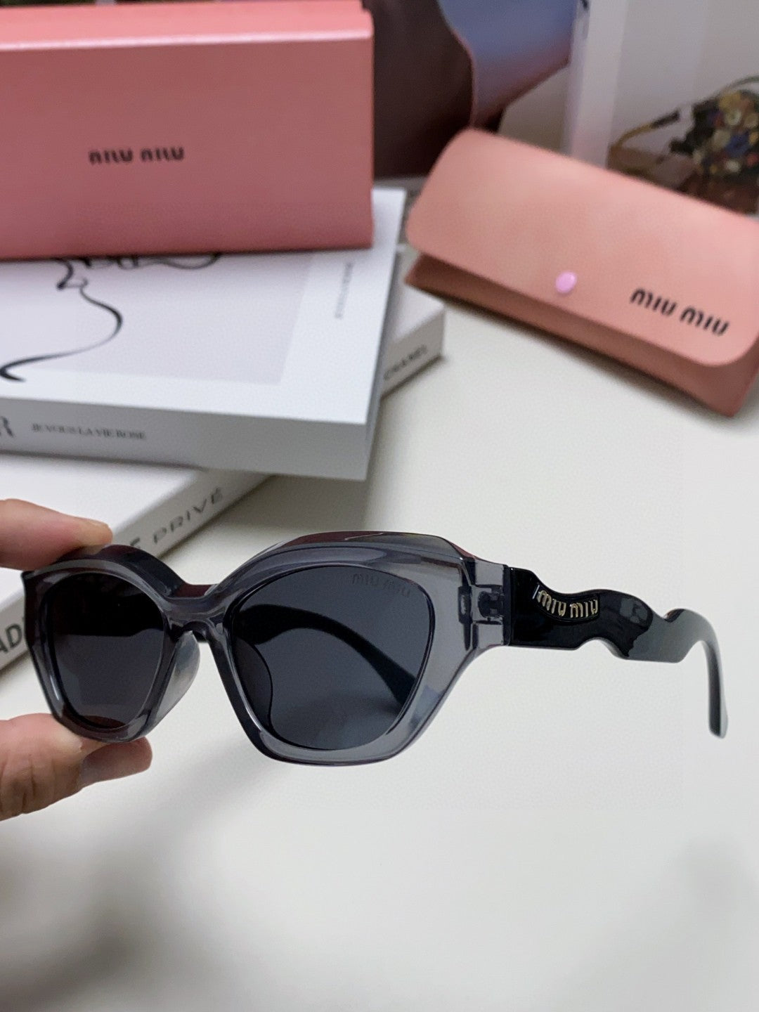 MIU MIU LOGO CAT EYE SUNGLASSES 513006 IN BLACK AND GREY CLEAR ACETATE WAVY FRAME